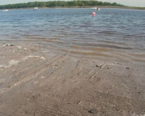 Tire tracks in the mud on the Addison boat launch ramp presumed to be from Krystal’s car with view of orange buoy marking where Krystal’s car was found.