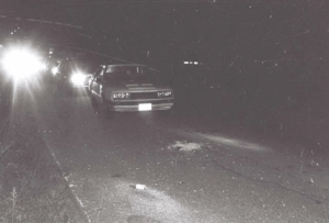 Front view of Kathy Perry’s Mercury Capri on the side of the road where it was abandoned. Note the beer can on the pavement.