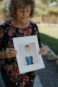 Michelle holds a photo of Chrissy in her formal dress